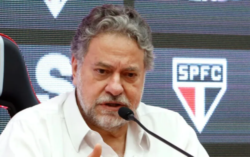 Casares, São Paulo FC president, at a press conference with serious expression, Morumbi stadium visible in background